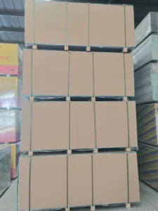 Large stacks of cardboard boxes secured with straps in a warehouse setting, surrounded by other packed materials.