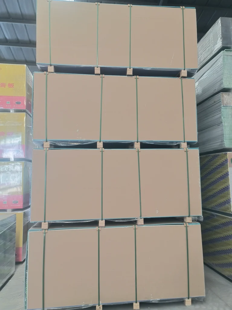Large stacks of cardboard boxes secured with straps in a warehouse setting, surrounded by other packed materials.