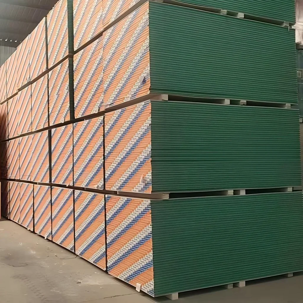 Large stacks of drywall pallets stored in a warehouse with alternating green and branded patterns.