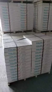 Pallet with numerous boxes labeled Trus stacked neatly in rows, secured by straps.
