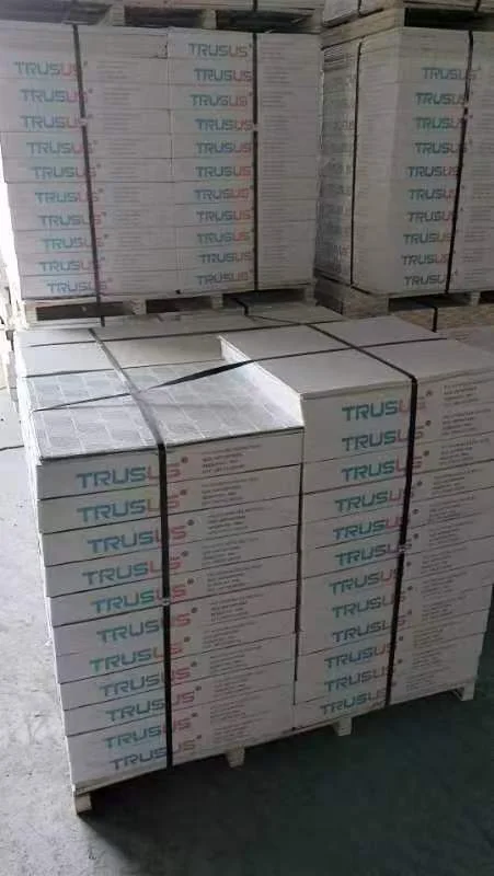 Pallet with numerous boxes labeled Trus stacked neatly in rows, secured by straps.