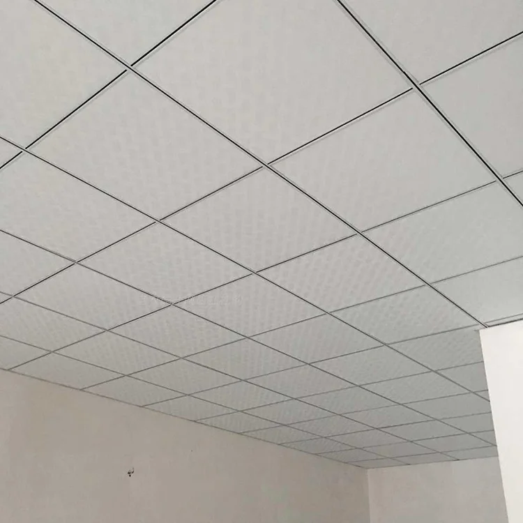 A suspended ceiling with white tiles arranged in a grid pattern, viewed from below, creating a modern and clean look.