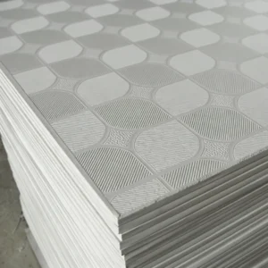 A stack of white ceiling panels with a geometric textured surface and striped patterns.